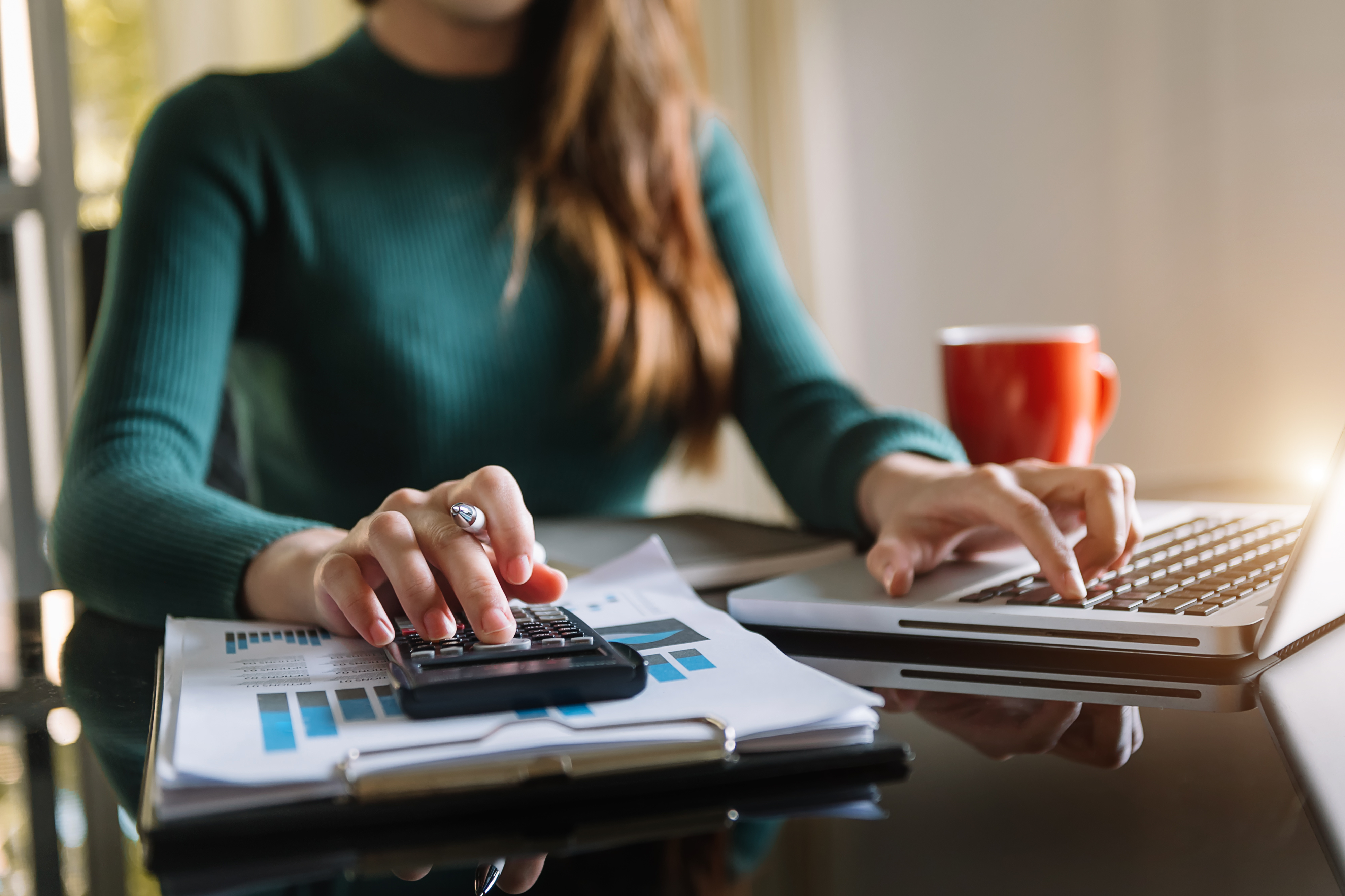 businessman working on desk office with using a calculator to calculate the numbers, finance accounting concept.