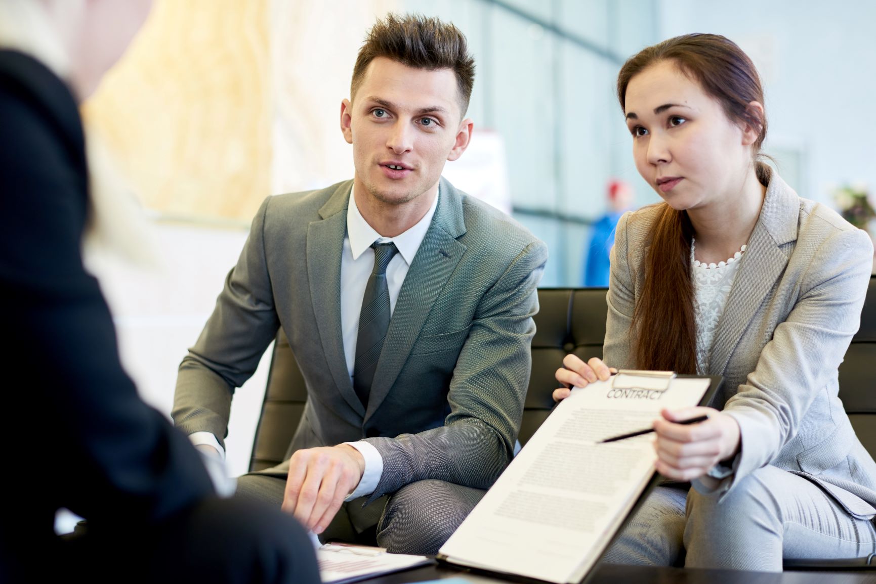 two young business professionals discussing need for outsourced fractional benefits specialists from Optima Office