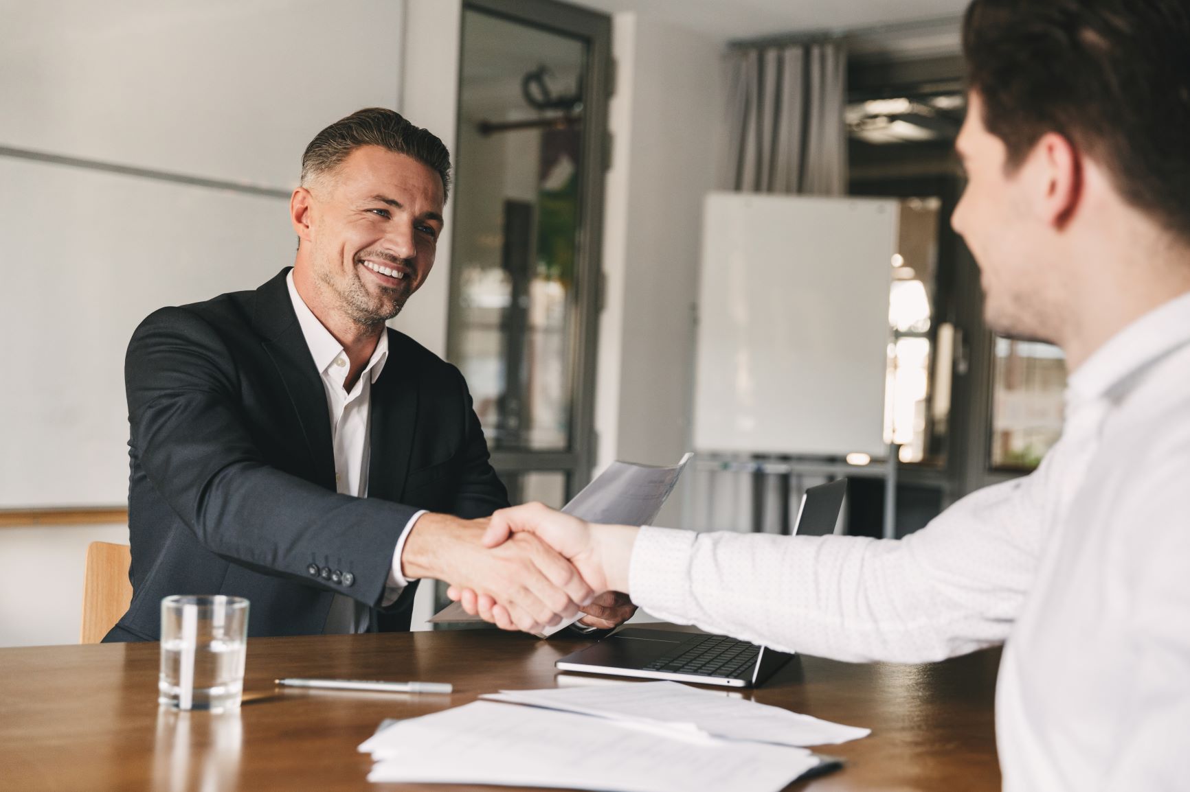 outsourced recruiting manager from Optima Office shaking hands with new recruit